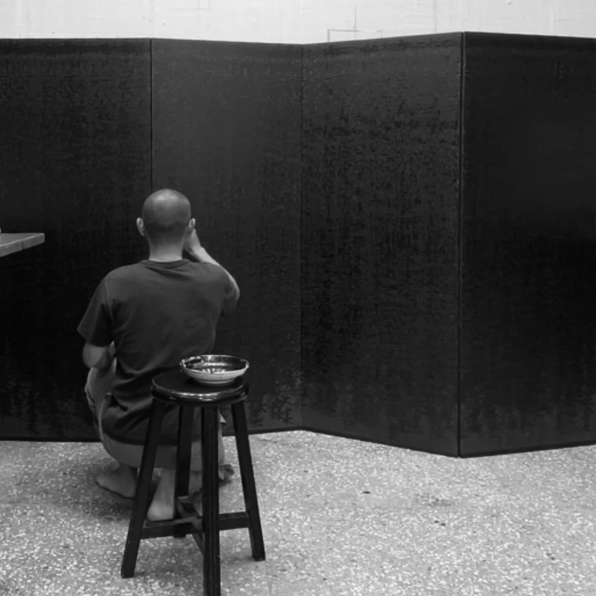 郭汶瑄於工作室背對畫面進行裝裱/創作的勞動肖像